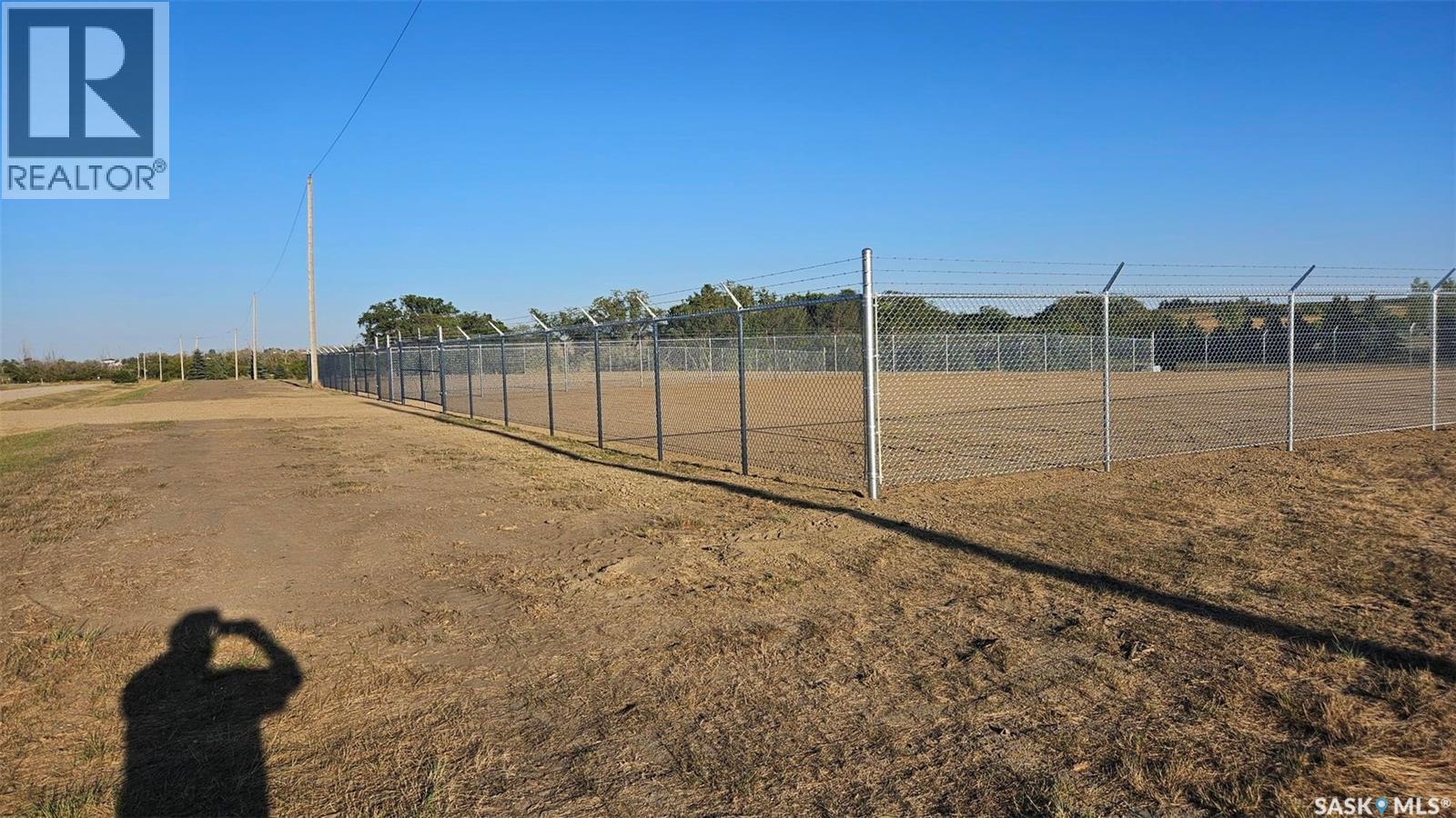 A person is taking a photo of a fenced field.