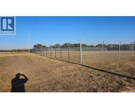 A person is taking a photo of a fenced field.