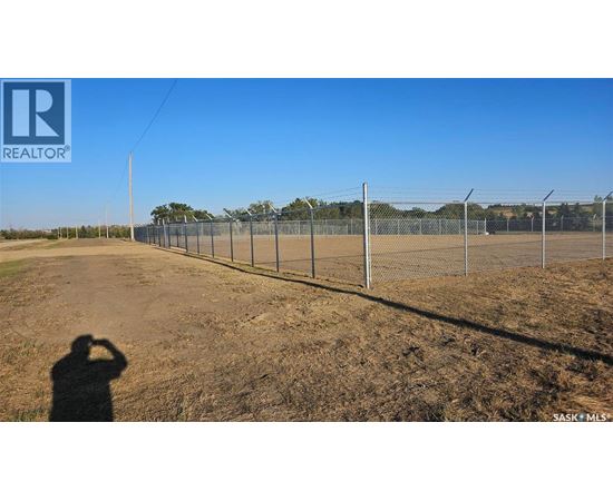 A person is taking a photo of a fenced field.