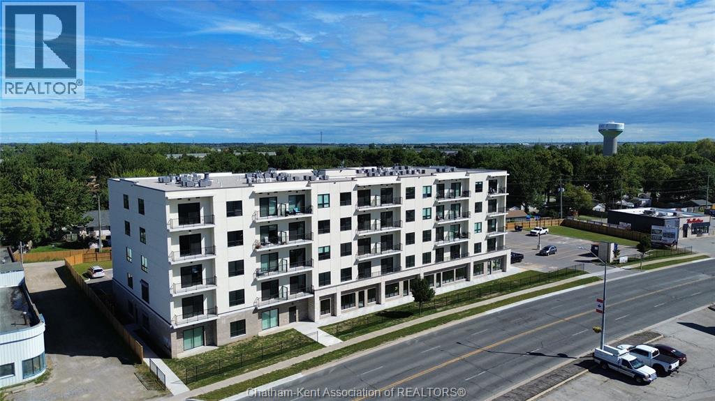 A large white building with a car parked in front of it.