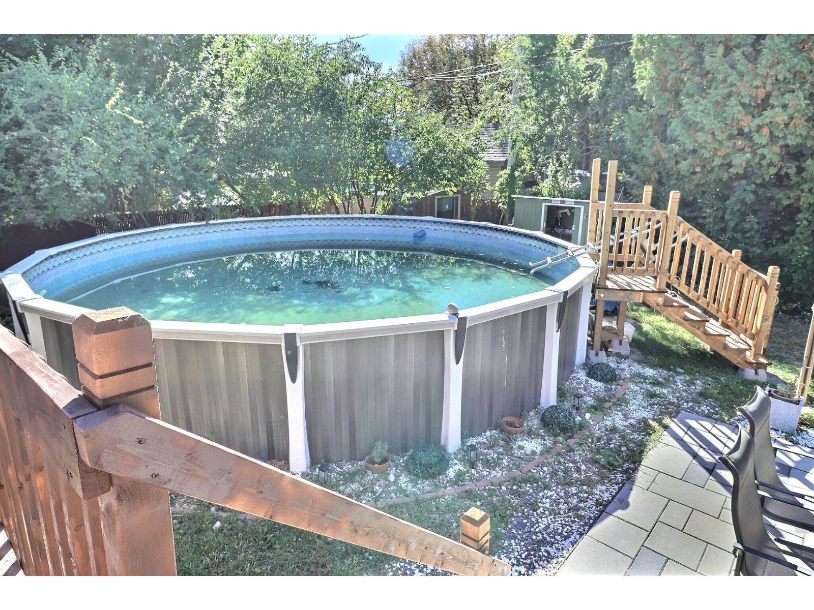A hot tub sits in a backyard surrounded by a wooden fence.