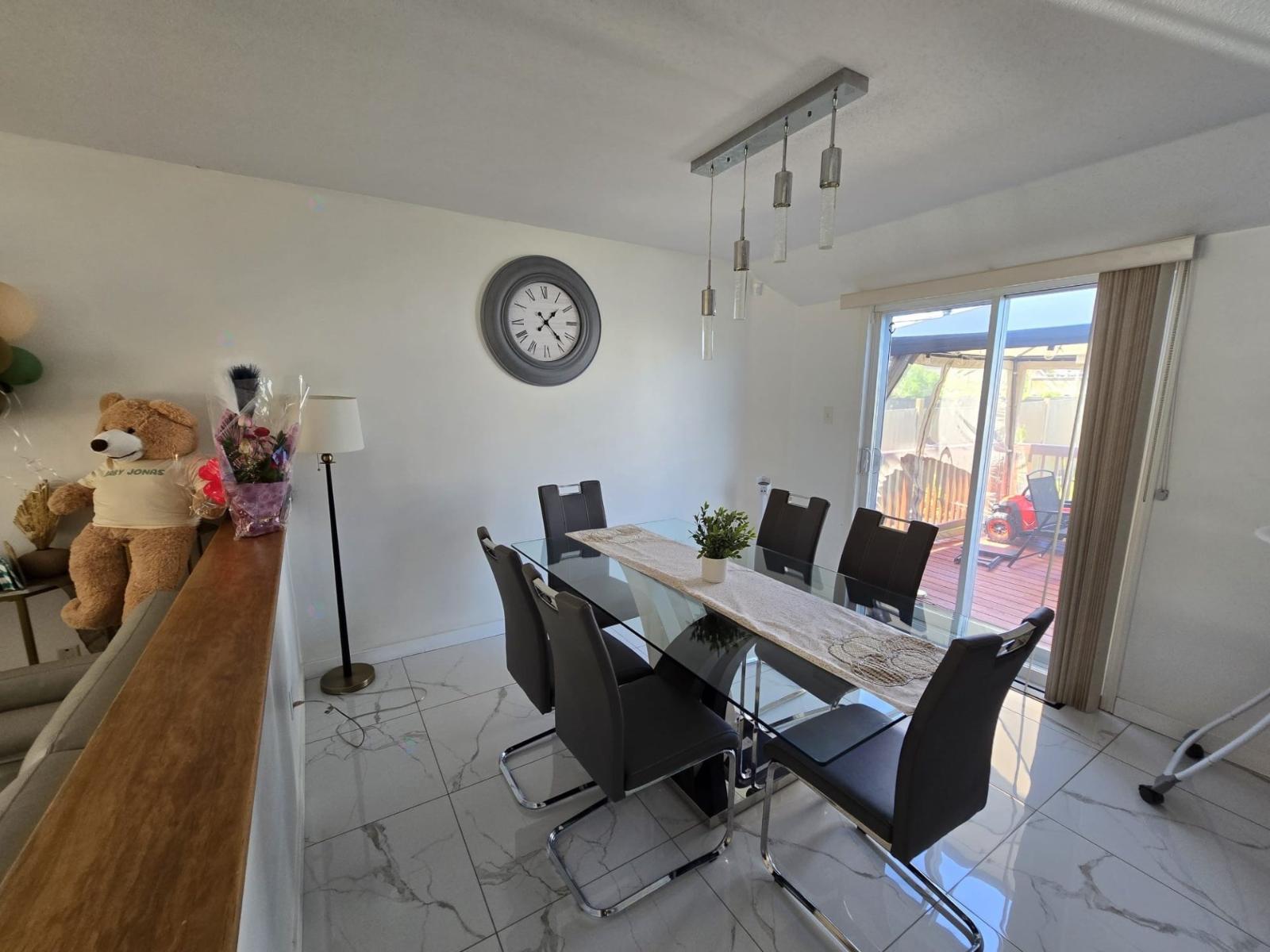 A dining room with a white table and black chairs.
