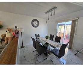 A dining room with a white table and black chairs.