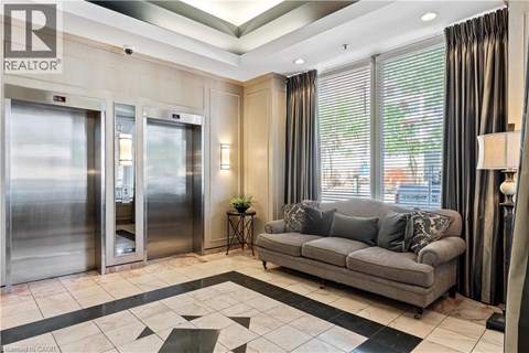 A living room with a grey couch and a black and white tiled floor.