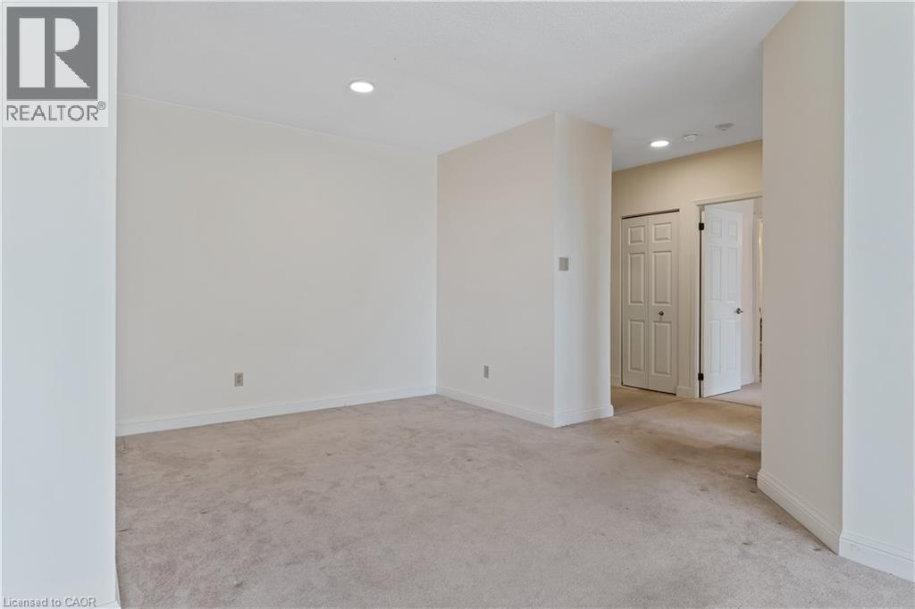 A spacious room with a carpeted floor and a doorway leading to another room.