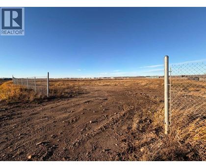 A barren landscape with a fence and a sign that says REALTOR.