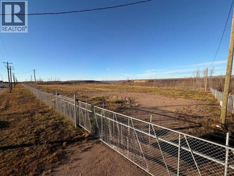 A chain link fence runs along the side of a dirt road.