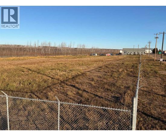 A fenced field with a REALTOR® logo in the corner.