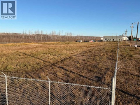 A fenced field with a REALTOR® logo in the corner.