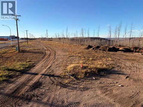 A dirt road with tire tracks leading to a construction site.