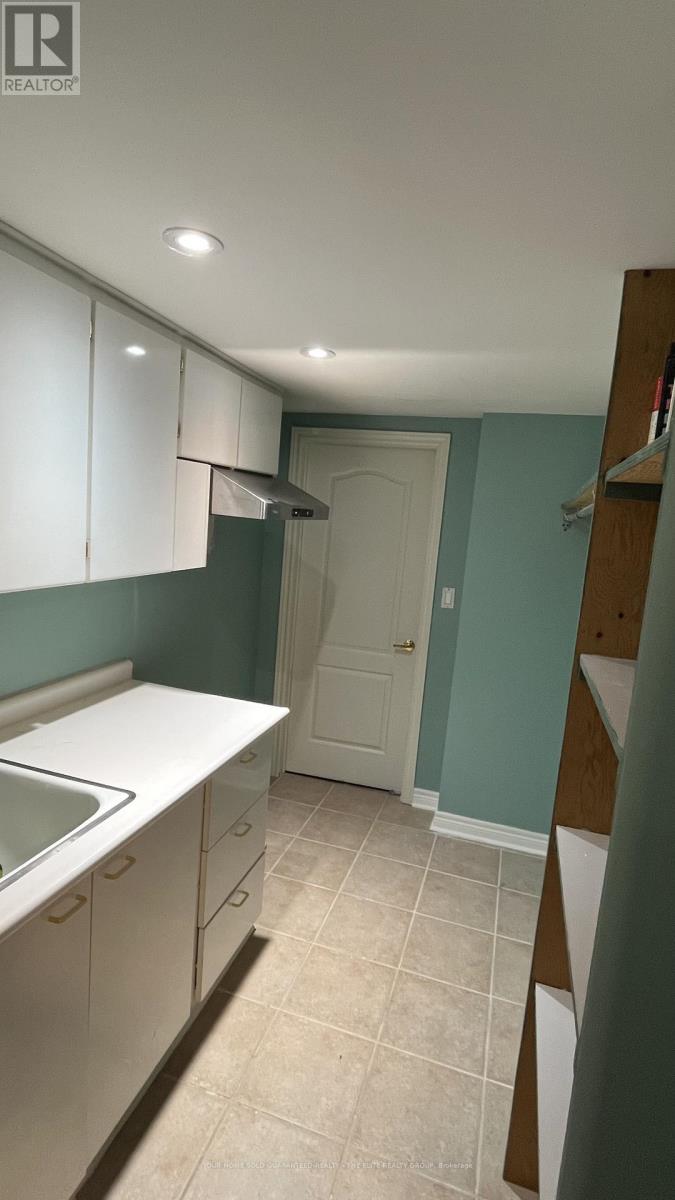 A kitchen with white cabinets and a white sink.