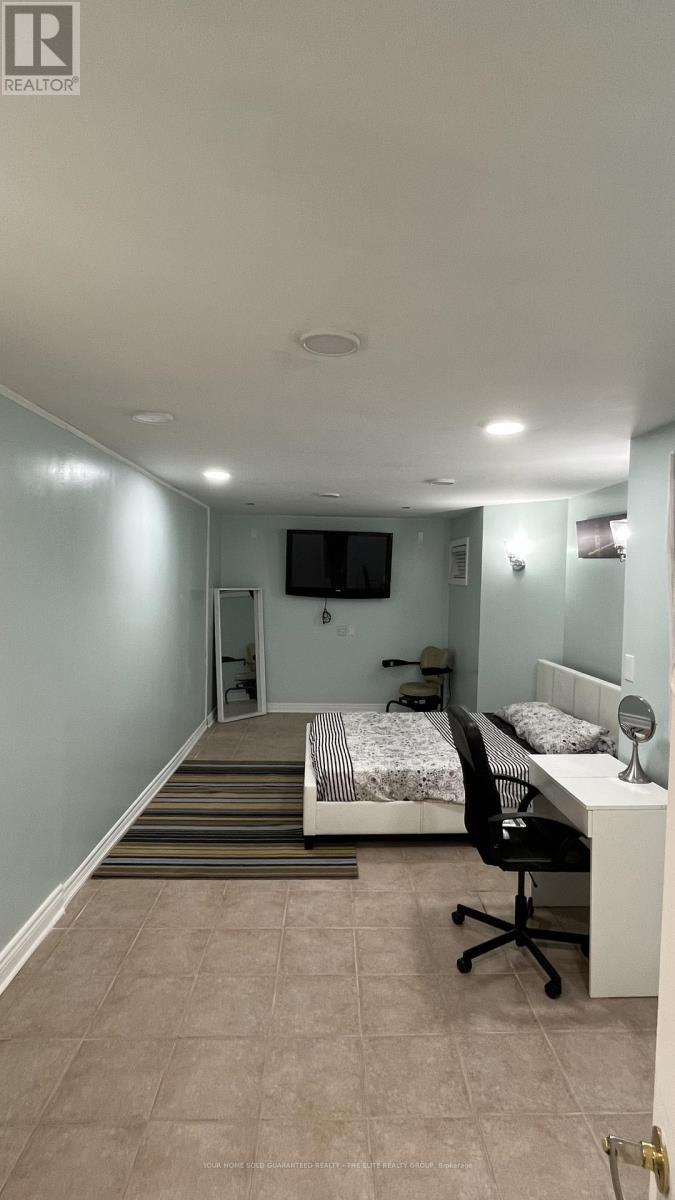 A bedroom with a bed, desk, and chair.