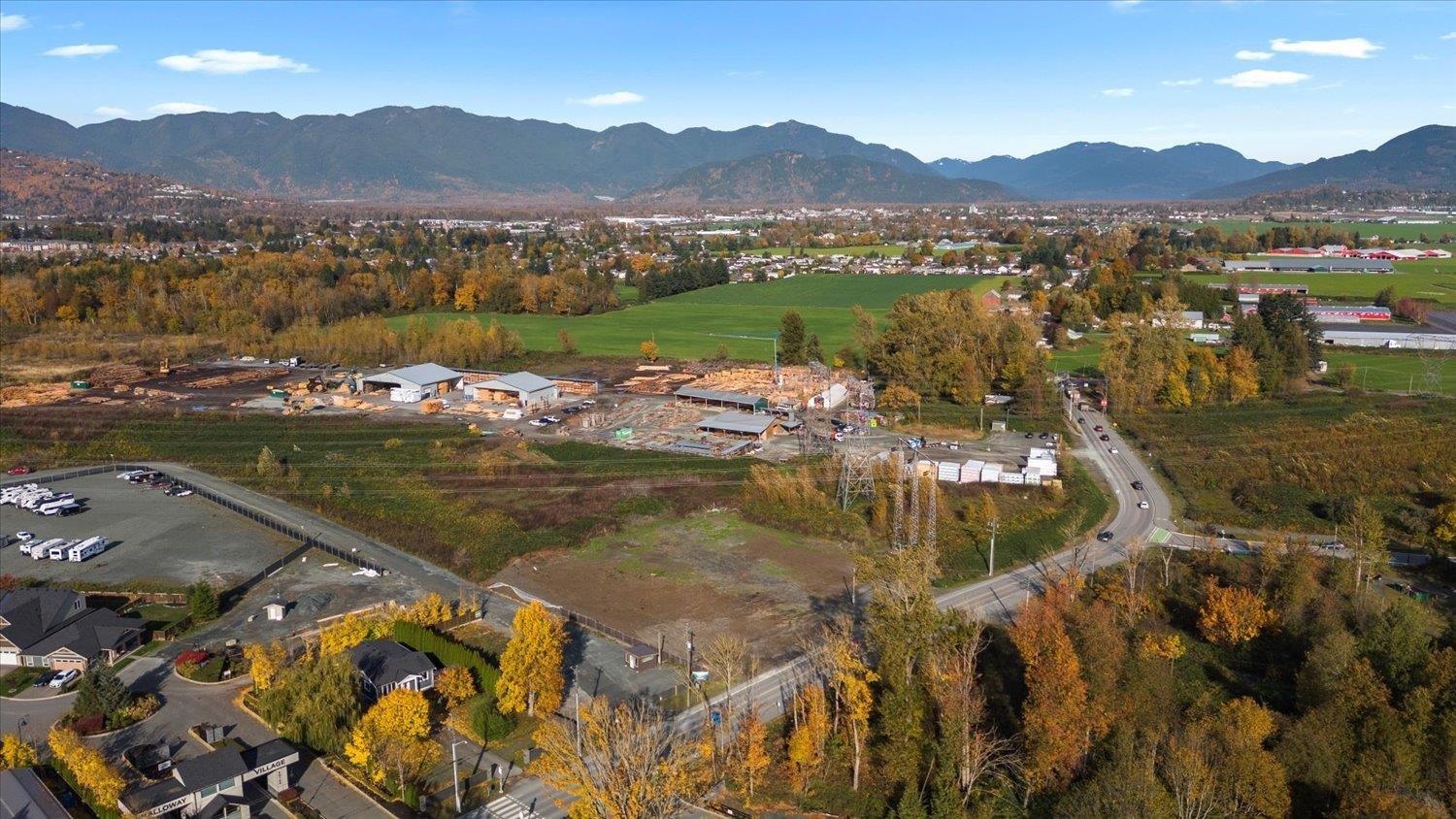 A small town with a large open field in the middle surrounded by mountains.