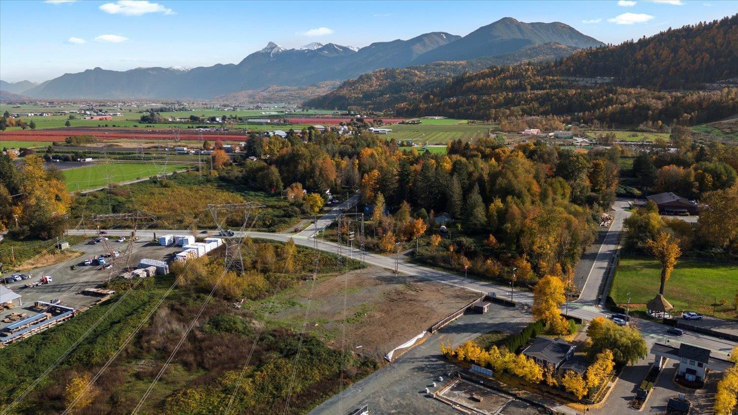 A small town with a parking lot in the foreground and mountains in the background.