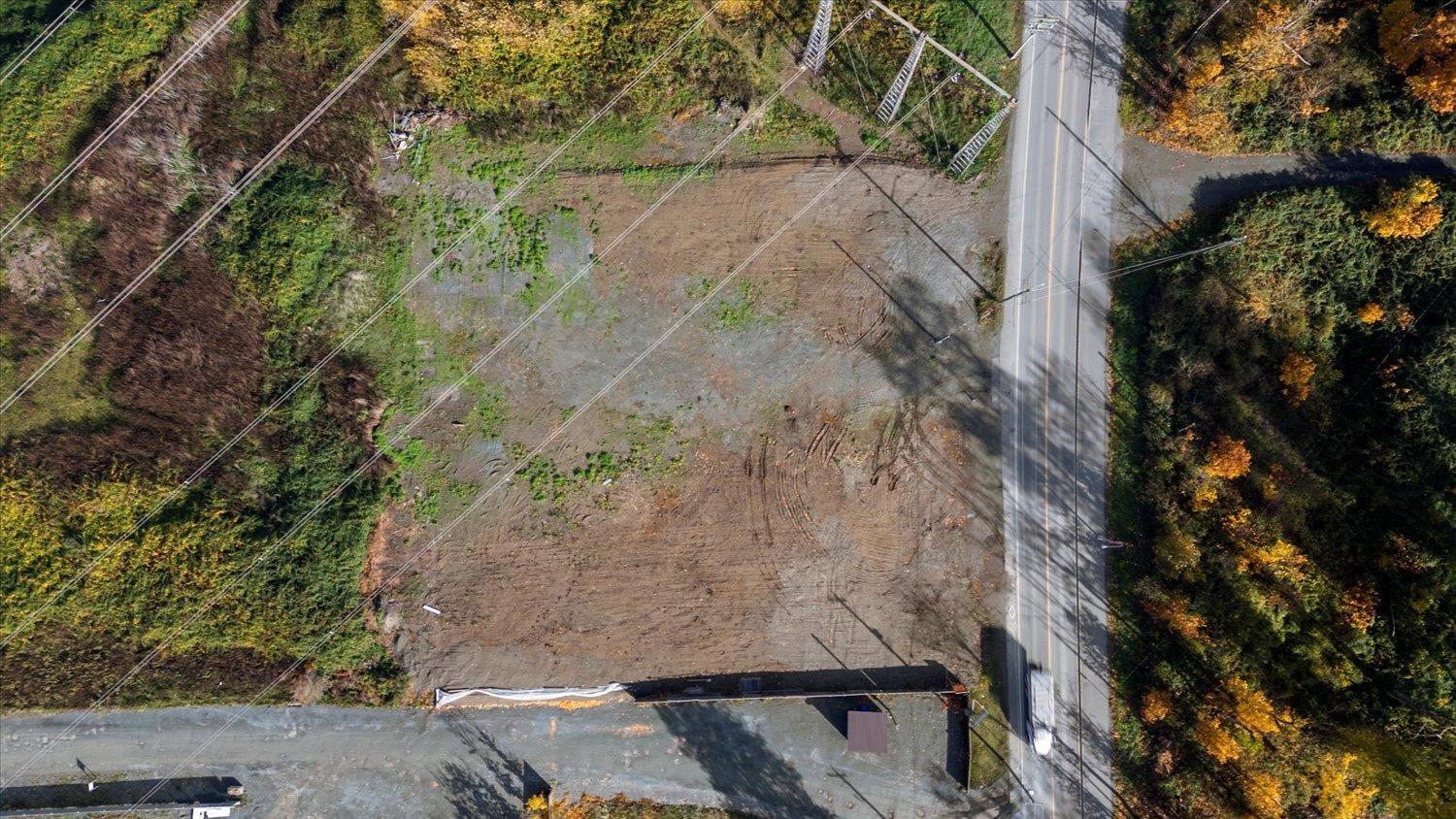 A road with a bridge and a small building on the side.