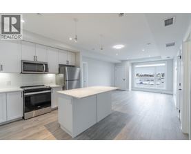 A modern kitchen with white cabinets and stainless steel appliances.
