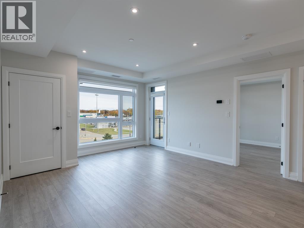 A spacious room with a large window and a sliding glass door.
