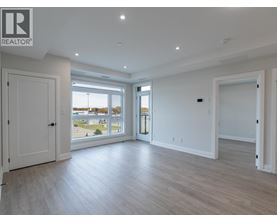 A spacious room with a large window and a sliding glass door.