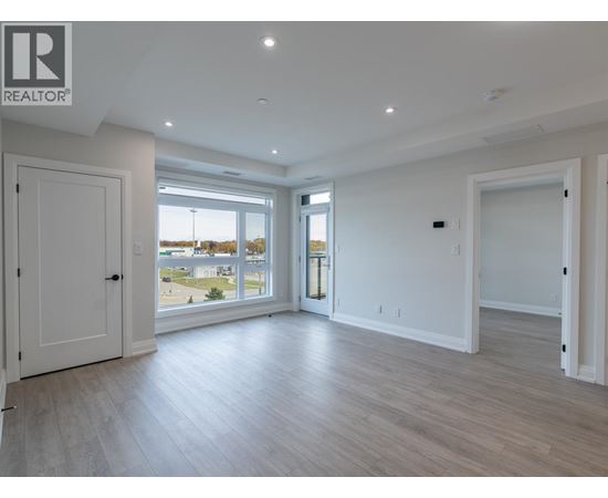 A spacious room with a large window and a sliding glass door.