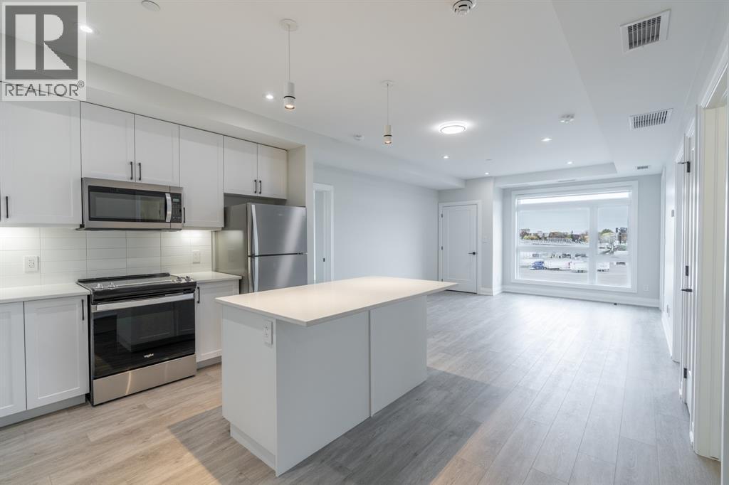 A modern kitchen with white cabinets and stainless steel appliances.
