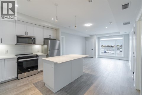A modern kitchen with white cabinets and stainless steel appliances.