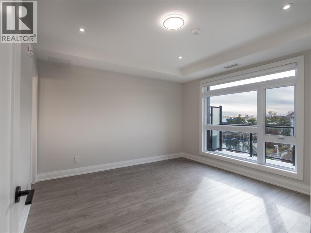A spacious room with a large window and wooden flooring.
