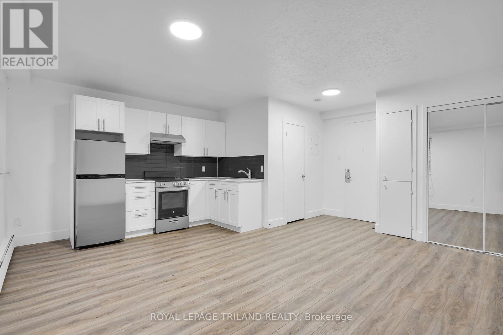 A spacious kitchen with white cabinets and stainless steel appliances.