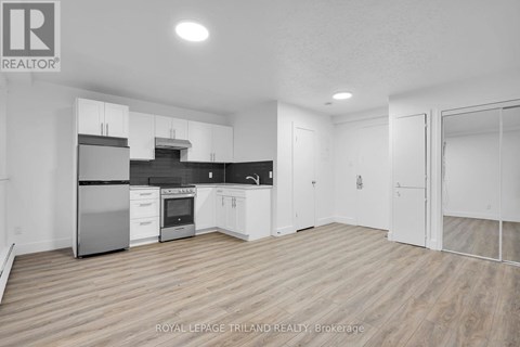 A spacious kitchen with white cabinets and stainless steel appliances.