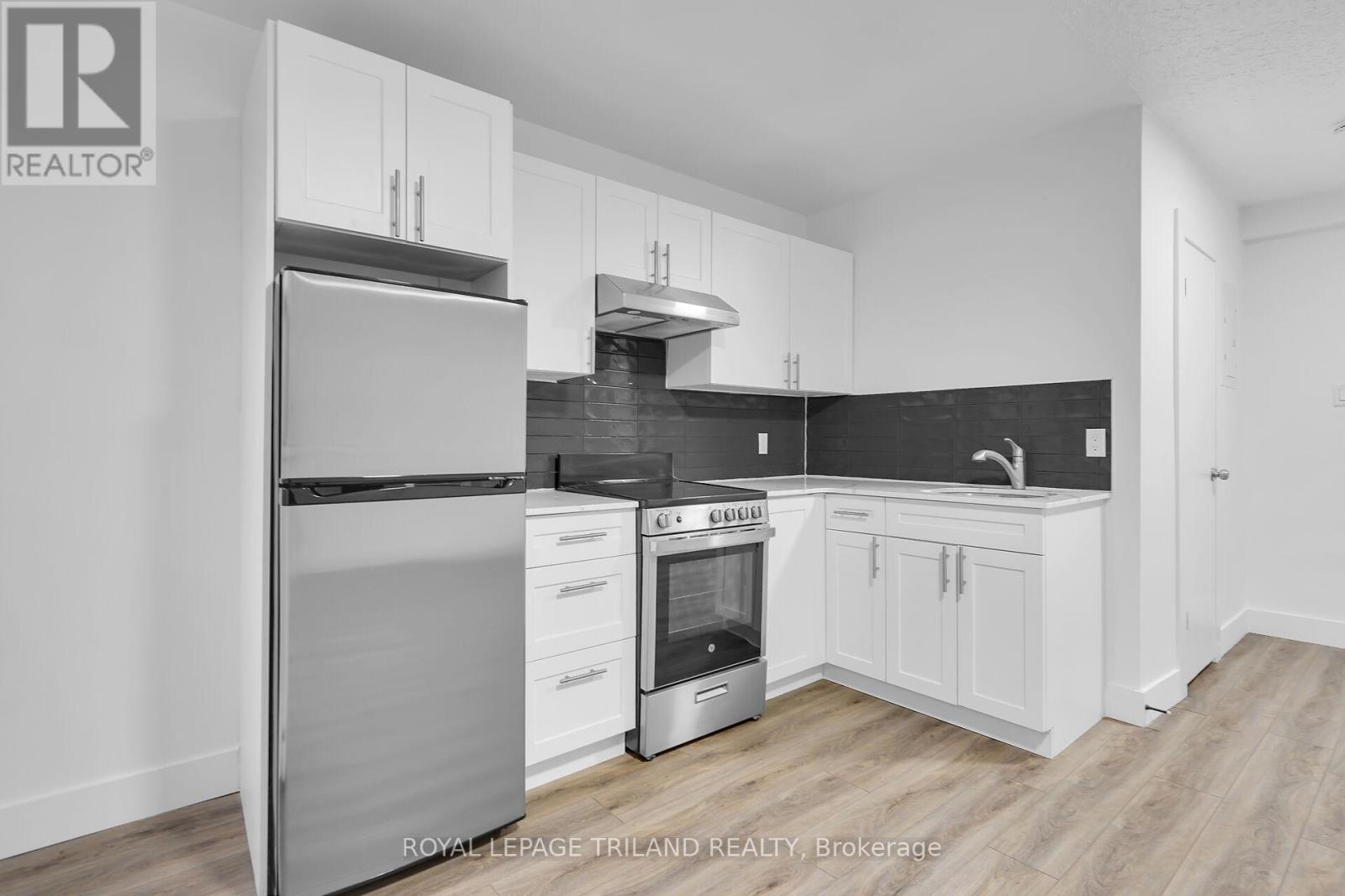 A modern kitchen with white cabinets and stainless steel appliances.