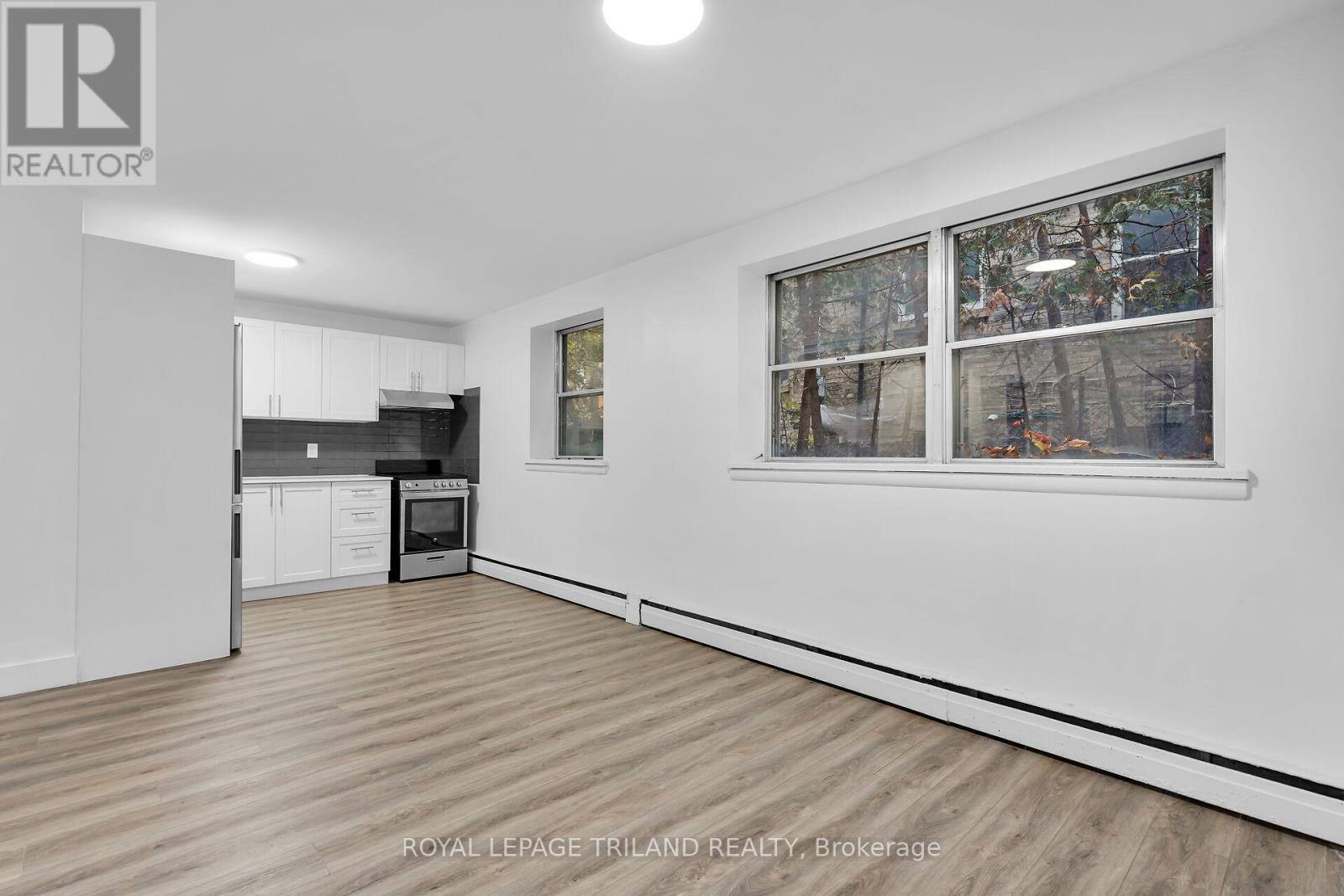 A white room with a window showing trees outside.