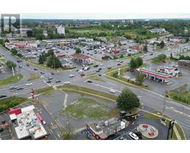 A busy intersection with a RE/MAX Rise Excellence Brokerage sign in the parking lot.