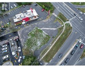 A parking lot with a building and a sign that says RE/MAX Rise Excavation Brokerage.