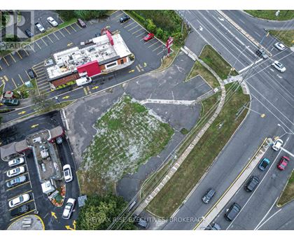 A parking lot with a building and a sign that says RE/MAX Rise Excavation Brokerage.
