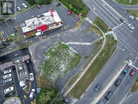 A parking lot with a building and a sign that says RE/MAX Rise Excavation Brokerage.