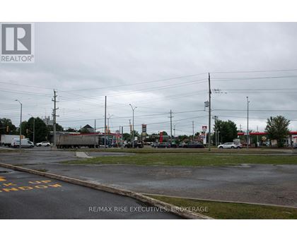 A street view with a sign for RE/MAX Rise Executives, Brokerage.