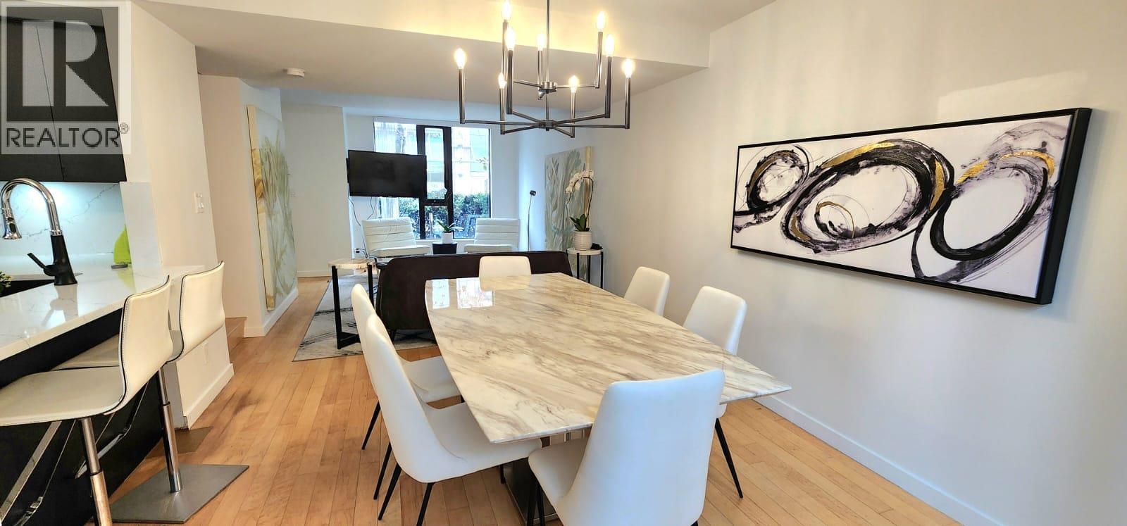 A dining room with a large table and chairs.