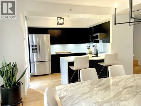 A modern kitchen with a dining table and chairs.