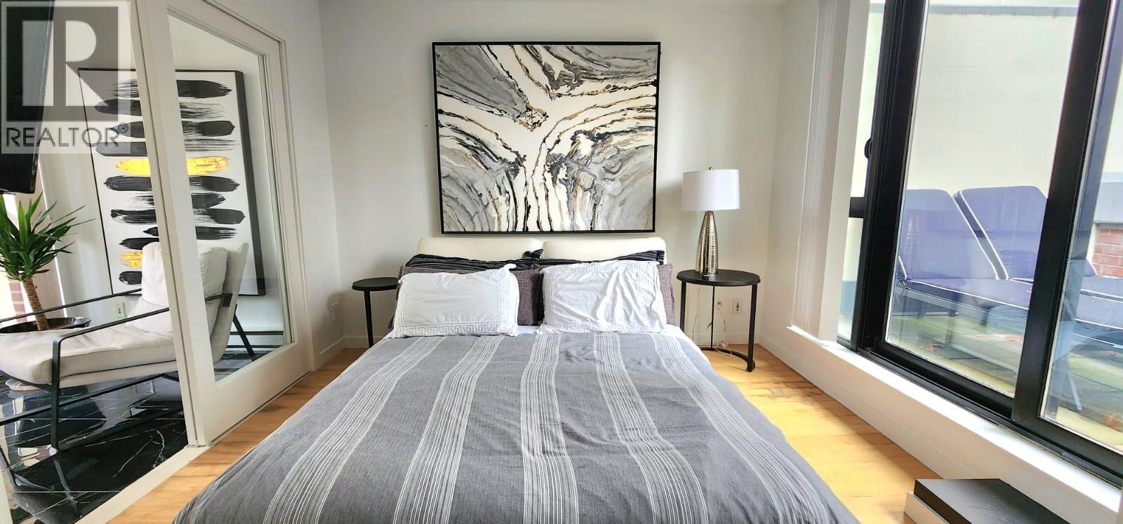 A bedroom with a large bed and a large window.