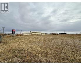 A field with a REALTOR® sign in the foreground.