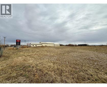 A field with a REALTOR® sign in the foreground.