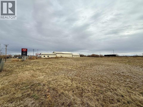 A field with a REALTOR® sign in the foreground.