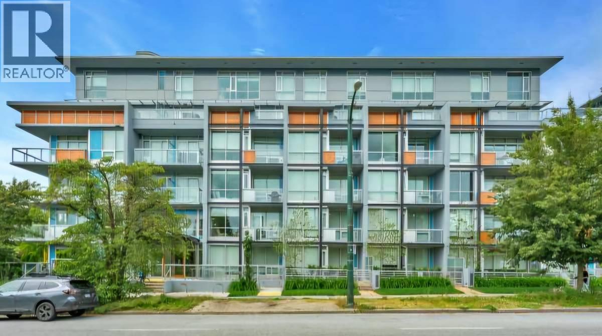 A modern apartment building with a car parked in front.