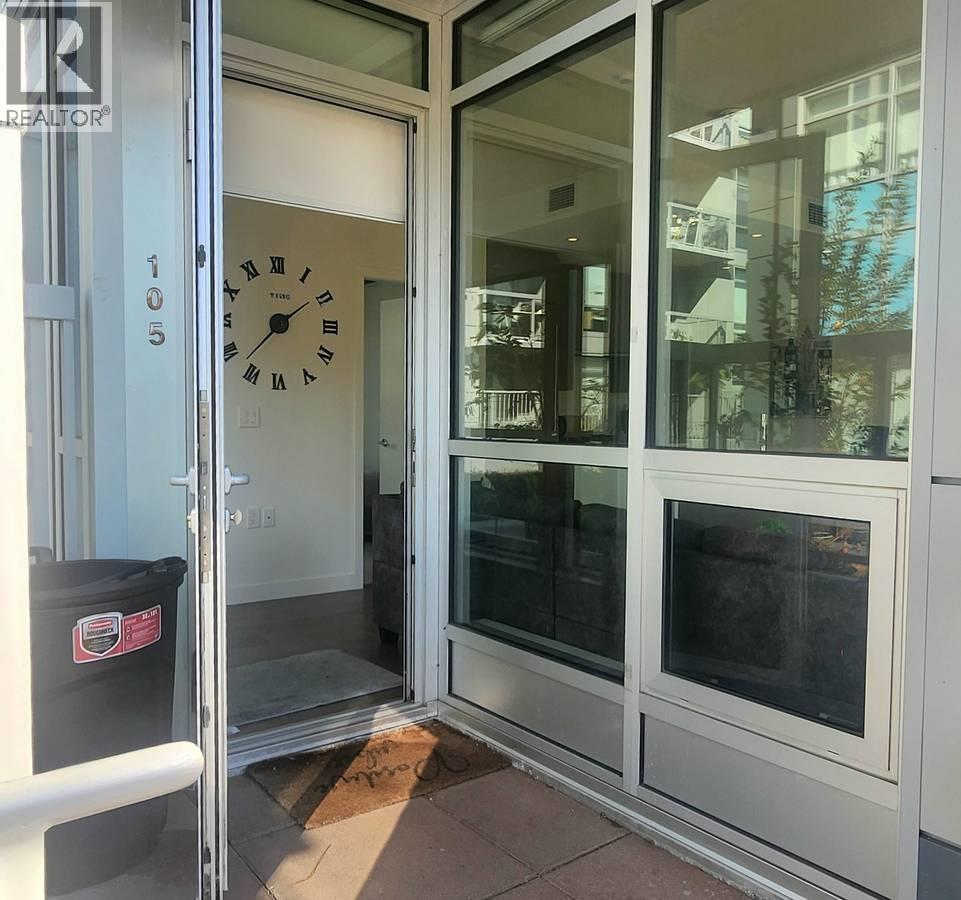 A clock is on the door of a glass door.