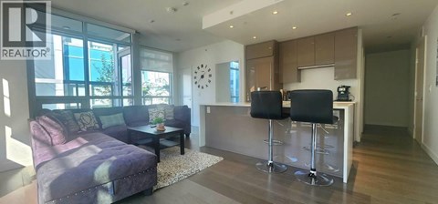 A modern living room with a purple couch and a bar area.