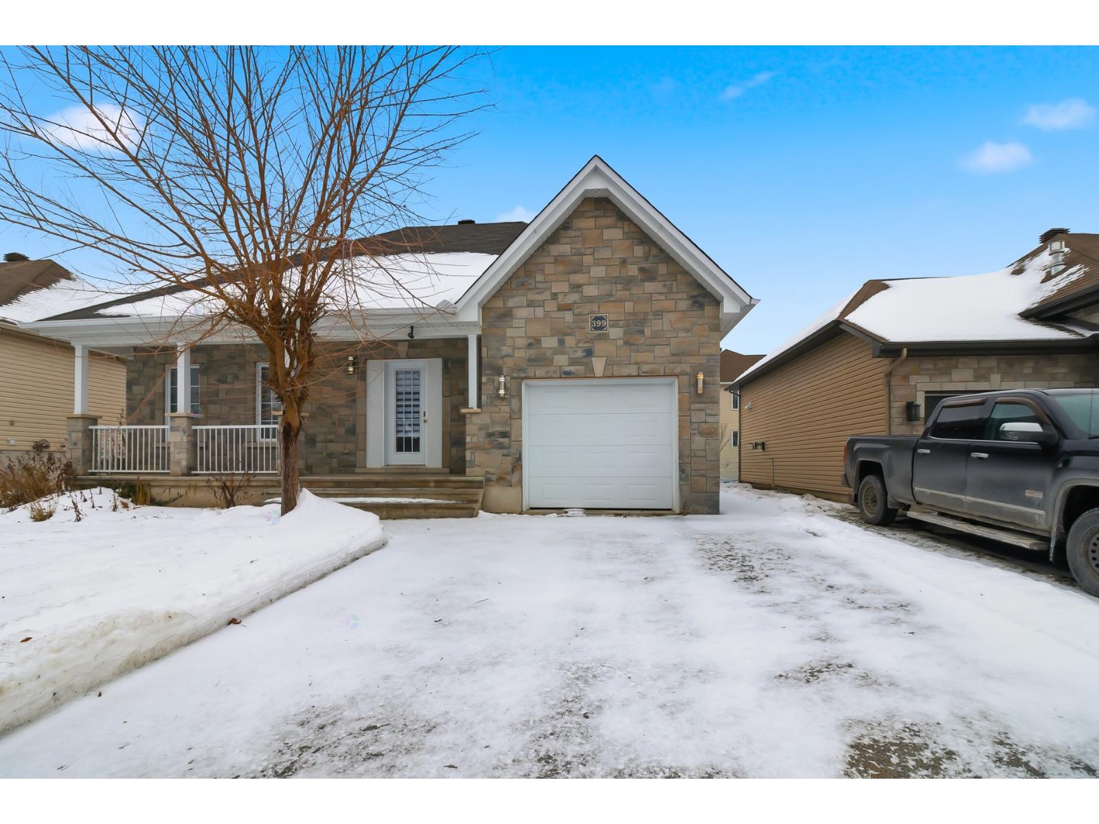 A house with a garage and a truck parked in front.