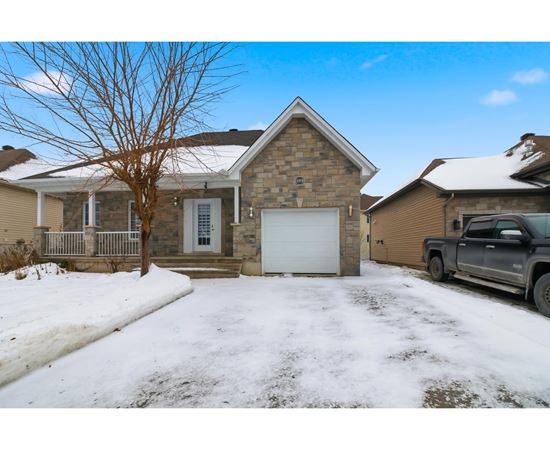 A house with a garage and a truck parked in front.