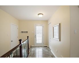 A hallway with a glass railing and a tiled floor.