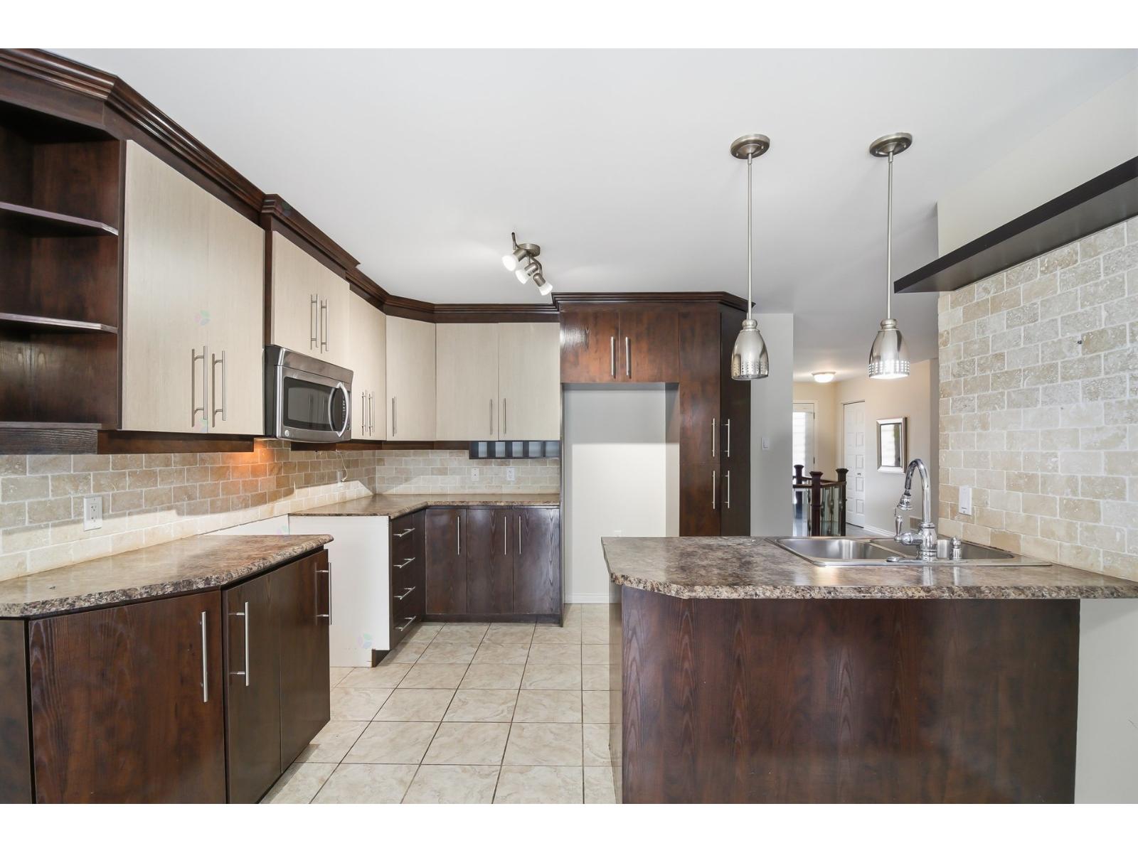 A kitchen with brown cabinets and a granite countertop.
