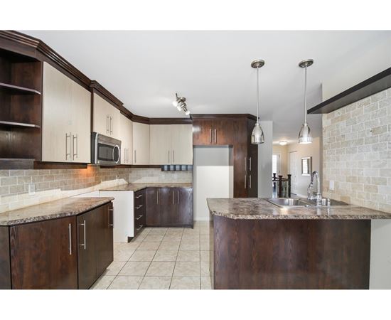 A kitchen with brown cabinets and a granite countertop.