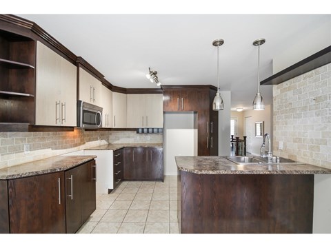 A kitchen with brown cabinets and a granite countertop.